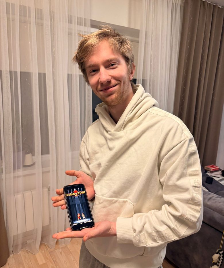 Ed holding his phone running ChampChase, the boxing RPG he shipped solo to beta